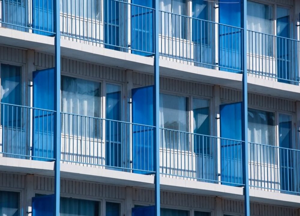closeup-shot-apartment-building-with-blue-balcony-dividers_181624-12671
